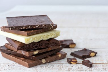 Fındık kakao tozu ve nane içeren farklı çikolata çeşitleri. Seçici odak, beyaz ahşap arka plan.