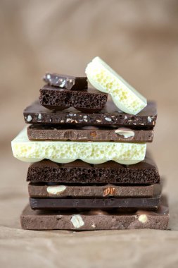 Fındık kakao tozu ve nane içeren farklı çikolata çeşitleri. Seçici odak, kahverengi kağıt kaplama arka plan.