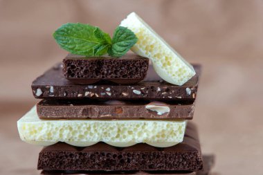 Fındık kakao tozu ve nane içeren farklı çikolata çeşitleri. Seçici odak, kahverengi kağıt kaplama arka plan.