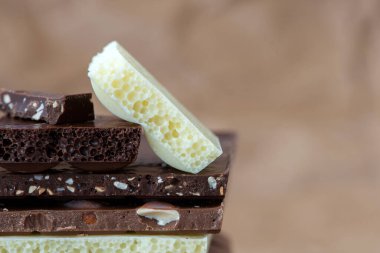 Fındık kakao tozu ve nane içeren farklı çikolata çeşitleri. Seçici odak, kahverengi kağıt kaplama arka plan.