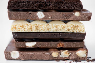 Fındık kakao tozu ve nane içeren farklı çikolata çeşitleri. Seçici odak noktası, beyaz arka plan.