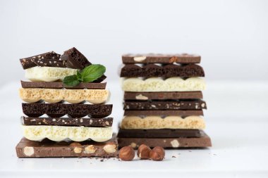 Fındık kakao tozu ve nane içeren farklı çikolata çeşitleri. Seçici odak noktası, beyaz arka plan.