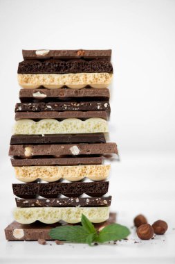 Fındık kakao tozu ve nane içeren farklı çikolata çeşitleri. Seçici odak noktası, beyaz arka plan.