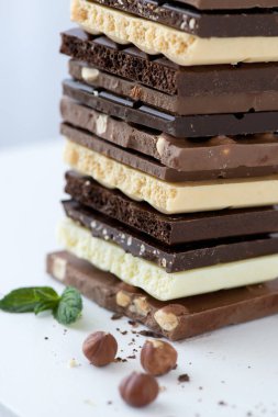 Fındık kakao tozu ve nane içeren farklı çikolata çeşitleri. Seçici odak noktası, beyaz arka plan.