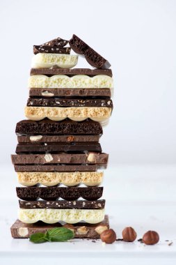 Fındık kakao tozu ve nane içeren farklı çikolata çeşitleri. Seçici odak noktası, beyaz arka plan.