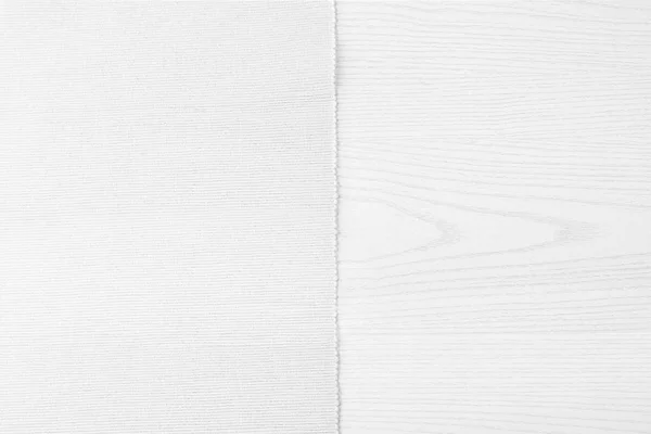 Biały materiał z lewej biały drewniany stół. — Zdjęcie stockowe
