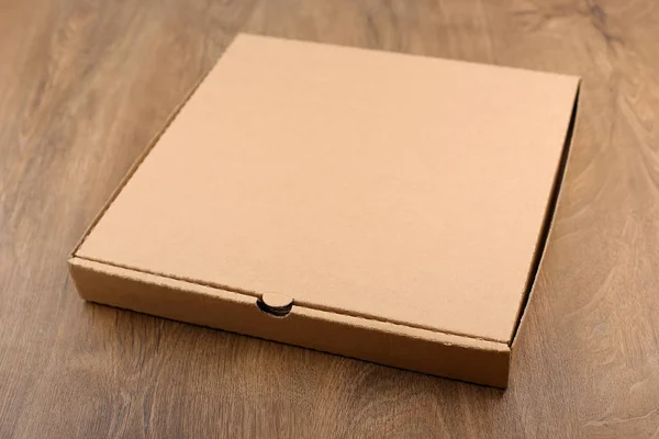 Caixa de papelão na mesa de madeira . — Fotografia de Stock