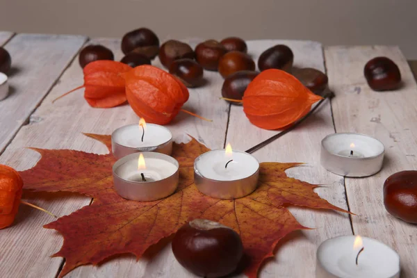 秋の植物の装飾や木製のテーブルの上のろうそく. — ストック写真