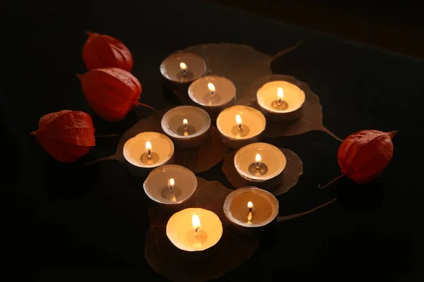 Горящие свечи с растительными украшениями в темноте . — стоковое фото