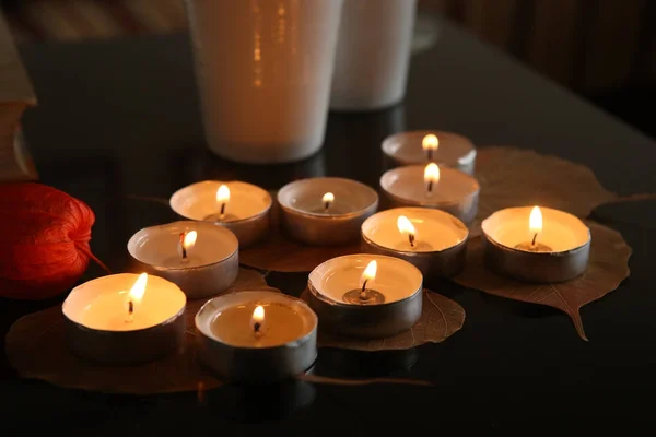 Горящие свечи с растительными украшениями в темноте . — стоковое фото