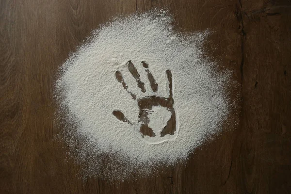 Hand print in flour. Hand print on floured wooden surface.