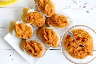 Beyaz ahşap masa üzerinde kabak dip sandviçle. Ev yapımı bitkisel (kabak, biber) sosu, üstten görünüm.