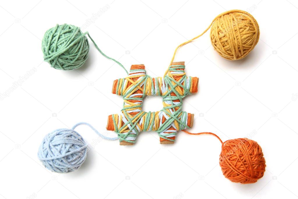 Hashtag made from cardboard and thread with colorful thread balls isolated on white background. Cotton thread balls made from different color (orange, yellow, green, blue) with hashtag sign.