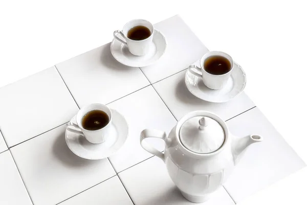 白色茶杯和茶壶放在白色瓷砖桌上 与白色背景隔离 — 图库照片