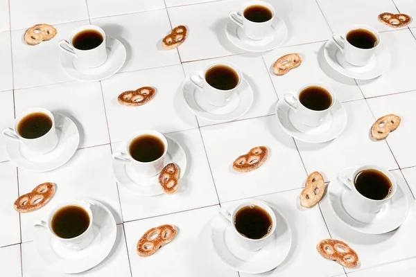 白瓷砖桌上的无缝制白咖啡杯和饼干 — 图库照片