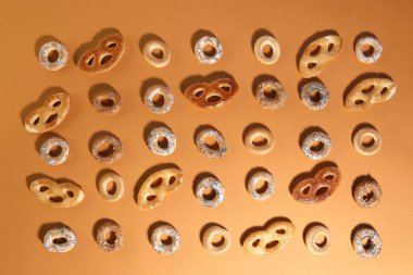 Bublik kurabiye deseni. Turuncu arka planda halka şeklinde rulo kurabiyeler