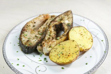 Patatesli fırında sazan parçaları. Balık sazan parçaları ve fırında pişirilmiş soyulmamış patatesler.