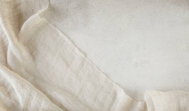 Hafif grunge taşından arka planda saf çamaşır bezi. Taş yüzeyinde doğal yıkanmış keten kumaş ve kopyalama alanı