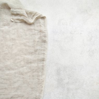 Hafif grunge taşından arka planda saf çamaşır bezi. Taş yüzeyinde doğal yıkanmış keten kumaş ve kopyalama alanı