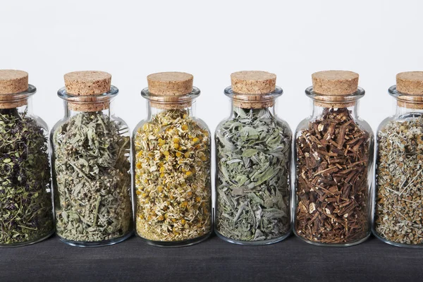 Cam şişeler içinde çay için otlar çeşitleri.
