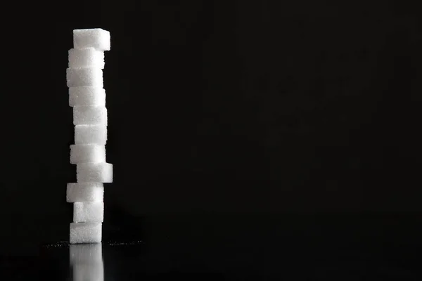 Bir sütundaki düzenlenmiş kesme beyaz şeker. 