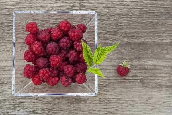 Bir cam kabın içinde organik ahududu.