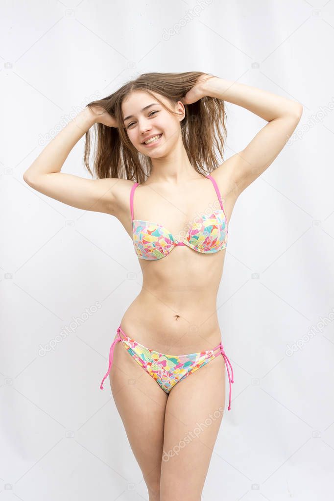beautiful young attractive girl in a swimsuit on a white background