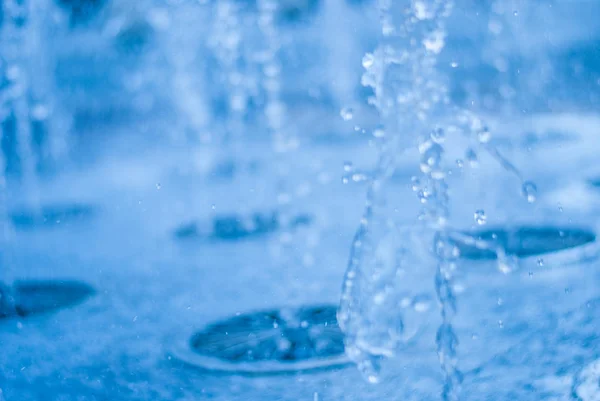 El chorro de agua de una fuente. Salpicadura de agua en la fuente, imagen abstracta — Foto de Stock