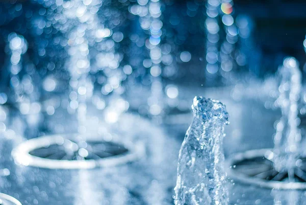 El chorro de agua de una fuente. Salpicadura de agua en la fuente, imagen abstracta — Foto de Stock