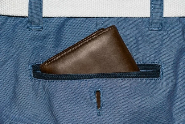 Brown leather purse in the pocket. Wallet halfway out from a jeans back. Pocket blue jeans with Wallet brown — Stock Photo, Image
