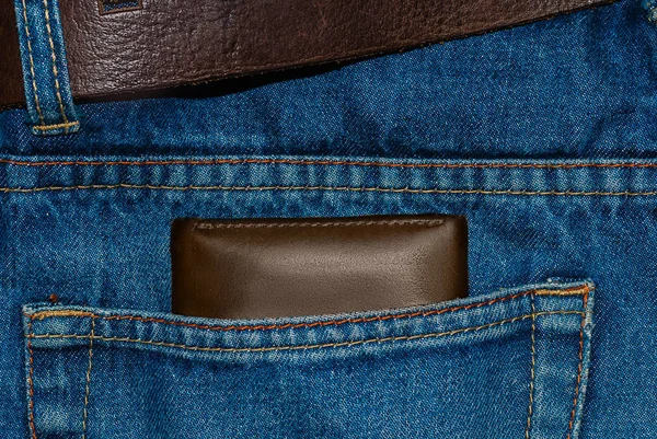 Καφέ δερμάτινο πορτοφόλι στην τσέπη. Πορτοφόλι στα μισά του δρόμου έξω από ένα τζιν πίσω. Τσέπη τζιν μπλε με πορτοφόλι καφέ — Φωτογραφία Αρχείου