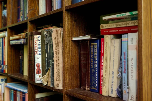 Книги на дерев'яних стелажах. старі та нові книги на дерев'яних полицях — стокове фото