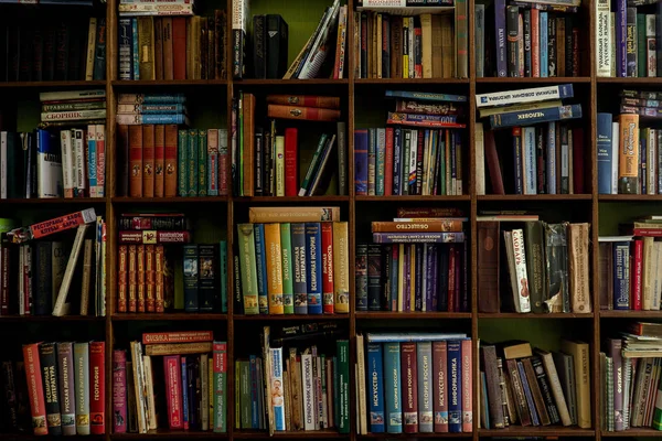 Книги на дерев'яних стелажах. старі та нові книги на дерев'яних полицях — стокове фото