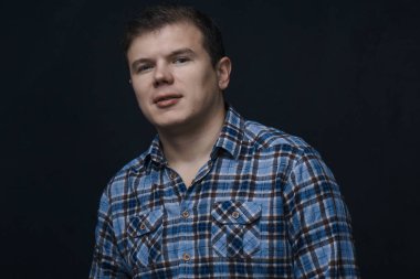 Siyah arka planda mavi bir kutuda gömlekli bir adam. Bir adamın portresi..