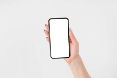 Beyaz ekranlı cep telefonuyla el ele tutuşan ve dokunan bir kadın.