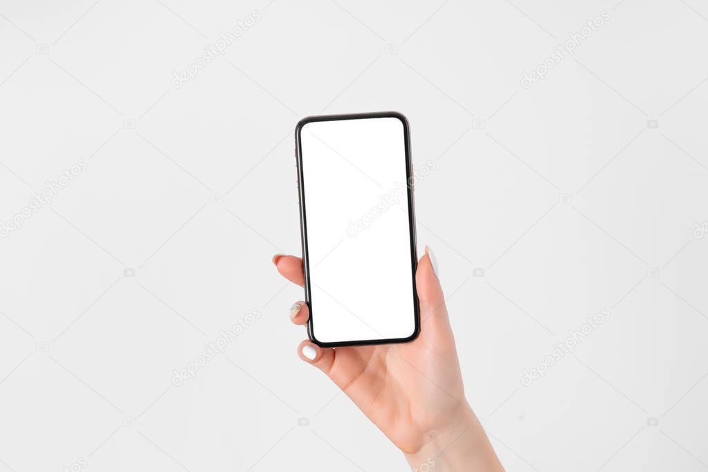 Female hand holding and touching on mobile smartphone with white screen
