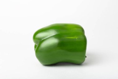 Beyaz arka planda izole edilmiş yeşil ve taze bir dolmalık biber. Sağlıklı vejetaryen yeme konsepti