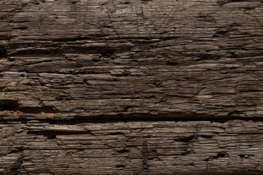 Bıçaktan derin kesikler ve balta darbeleriyle çok eski ve hırpalanmış bir ahşap arka plan. Böcekler tarafından tahrip edilmiş ağaç. Güneşin altında bir tahta, kar, yağmur ve rüzgar. Yaşlanmış ağaç