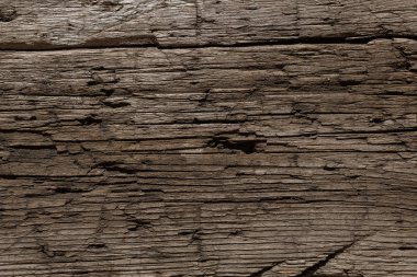 Bıçaktan derin kesikler ve balta darbeleriyle çok eski ve hırpalanmış bir ahşap arka plan. Böcekler tarafından tahrip edilmiş ağaç. Güneşin altında bir tahta, kar, yağmur ve rüzgar. Yaşlanmış ağaç