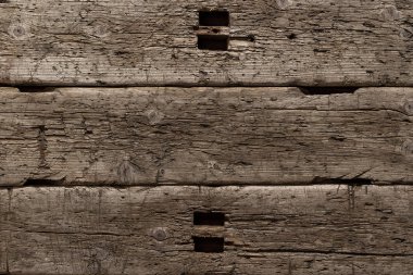 Bıçaktan derin kesikler ve balta darbeleriyle çok eski ve hırpalanmış bir ahşap arka plan. Böcekler tarafından tahrip edilmiş ağaç. Güneşin altında bir tahta, kar, yağmur ve rüzgar. Yaşlanmış ağaç