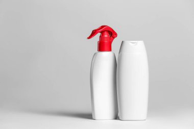 Açık arkaplanda beyaz ve gri kaplarda kozmetik ürünleri seti.