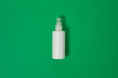 Kozmetik, Nemlendirici, Şişe. Boş plastik kozmetik şişesi, kopyalama alanı olan yeşil arkaplanda izole edilmiş.