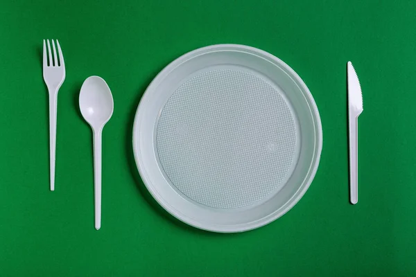 Utensilios Desechables Plástico Sobre Fondo Verde Tenedor Cuchillos Platos —  Fotos de Stock