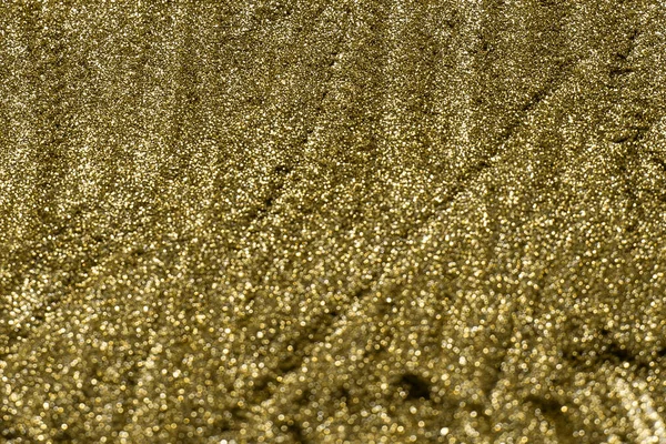 Detailed texture of glittering golden dust surface. Golden Shiny Wallpaper , Perfect for Christmas, New Year or any other Holidays Background. Golden fine powder.