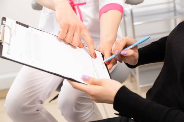 Bir kadın dişçiye geldi. Doktor bir form doldurur ve hastalar üzerinde bir anket yapar. Herkes gülümsüyor. Beyaz, modern bir dişçi ofisinde bulunmaktadırlar..