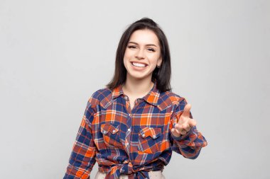 Güzel genç kadın portresi. Beyaz-gri bir gömlekle gülümseyen güzel bir esmerin portresi.