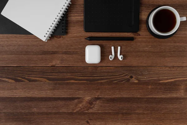 Notebook, graphics tablet, pencil and pen lie on a wooden brown table. Concept for designer or digital artist. Image with place for your text