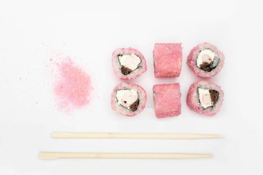 Japon mutfağı. Maki suşisi. Beyaz arka planda izole edilmiş. Suşi ruloları beyaz arka planda yatar, üst manzarada, onların yanında Japon bambu çubukları bulunur. Japon restoranının menüsü için kavramsal fikir