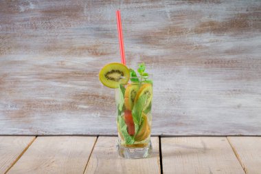 İki ferahlatıcı yaz kokteyli limon ve nane, kivi ve salatalık Sarı tahta bir masada