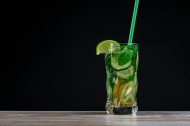 Citrus meyvesi ve otlar, tahtadan yapılmış cam şişelerde arınma veya diyet için sassi suyu, koyu arka plan, seçici odak, kare mahsul. Temiz yemek, kilo kaybı, sağlıklı yaşam tarzı konsepti.